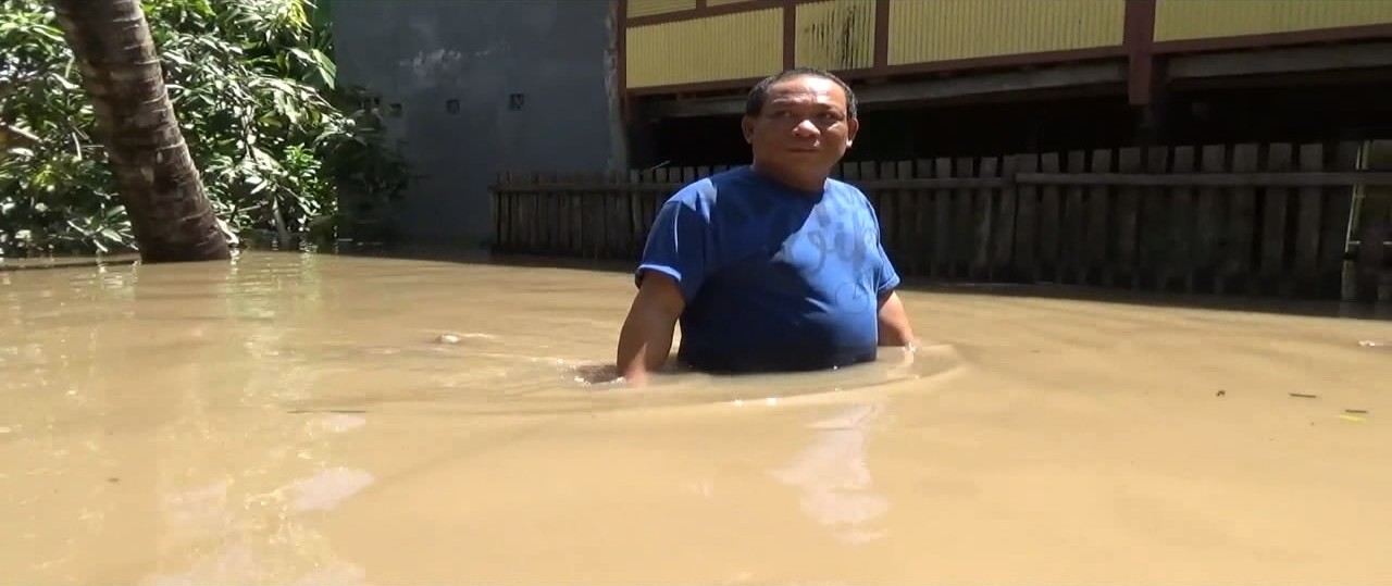 Ket; Seorang warga Kelurahan Bukit Harapan berjalan menerobos banjir, Sabtu 16/12 (foto: Amir/PIJAR)