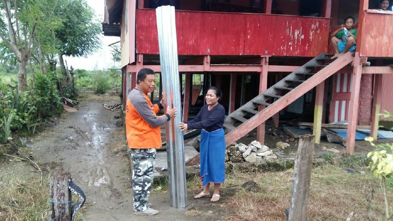 Ket: Salah satu petugas BPBD Barru menyerahkan bantuan seng kepada korban bencana puting beliung, yang terjadi pekan lalu. (foto: Fandy/PIJAR)