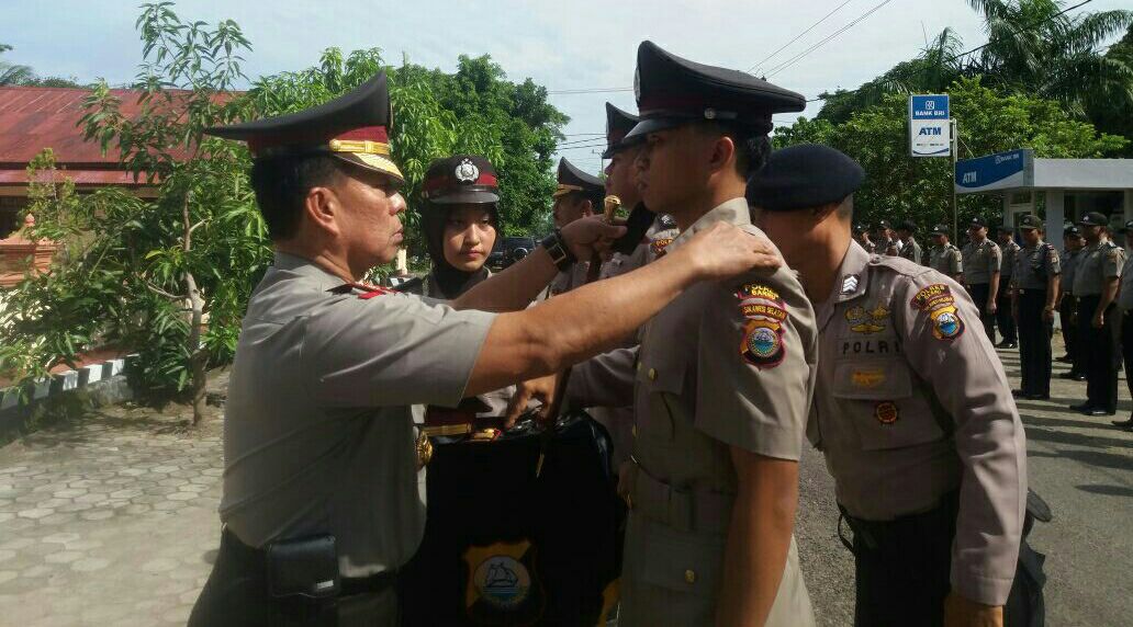 Kapolres Barru AKBP Burhaman menyematkan emblem kepada tiga personel Polres Barru yang naik pangkat, Selasa (2/1). 
--fyd--