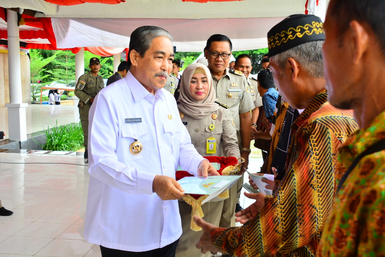 Bupati Sidrap H Dollah Mando menyerahkan sertifikat tanah kepada warga.