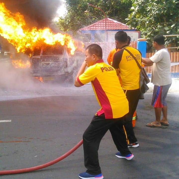 Kapolsek Dua Pitue, Iptu Ramli Kamran beserta sejumlah anggotanya berupaya memdamkan api yang membakar sebuah mobil kijang