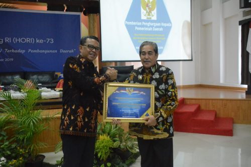 Gubernur Sulsel Nurdin Abdullah menyerahkan penghargaan ke Bupati Sidrap Dollah Mando. --Foto Kominfo Pemkab Sidrap--