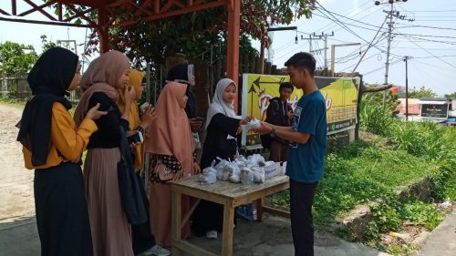 Mahasiswa IAIN Parepare sedang memberikan nasi bungkus kepada warga. --foto hamdan/pijarnews--