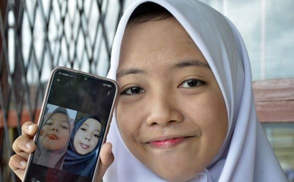 Nabila Azzahrah (16) memperlihatkan foto saudara kembarnya yang ditemuinya melalui media sosial Twitter, di Kabupaten Gowa, Sulawesi Selatan, Senin (13/1). [ANTARA FOTO/Abriawan Abhe]