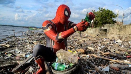 Rudi Hartono yang memakai pakaian ala Spiderman sedang memilah sampah plastik di pesisir pantai Parepare. --detiknews--