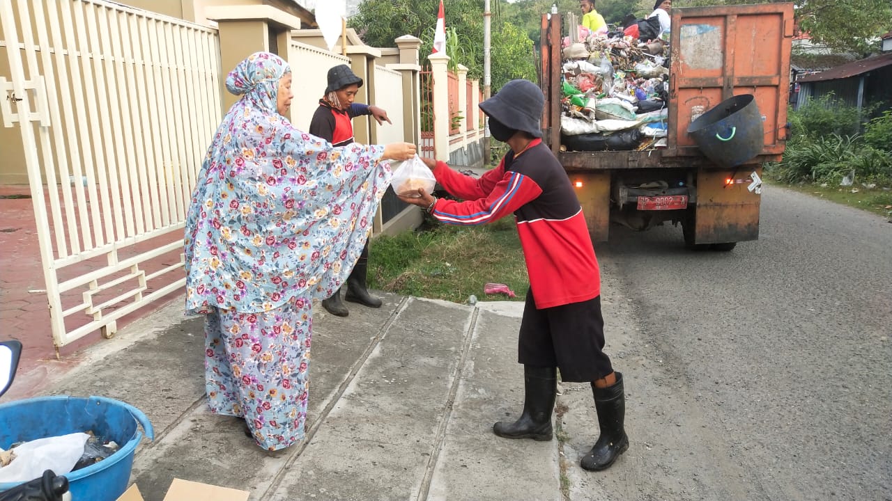 Andi Nurhanjayani saat berbagi sarapan dengan petugas kebersihan di depan rumahnya, di Lumpue, Jumat lalu.