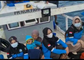 Petugas vaksinasi Liukang Kalmas Kabupaten Pangkep di atas kapal yang menuju Pulau Dewakkang, Kabupaten Pangkajene Kepulauan, Sulsel duduk berdampingan  saat bertugas beberapa waktu lalu.
