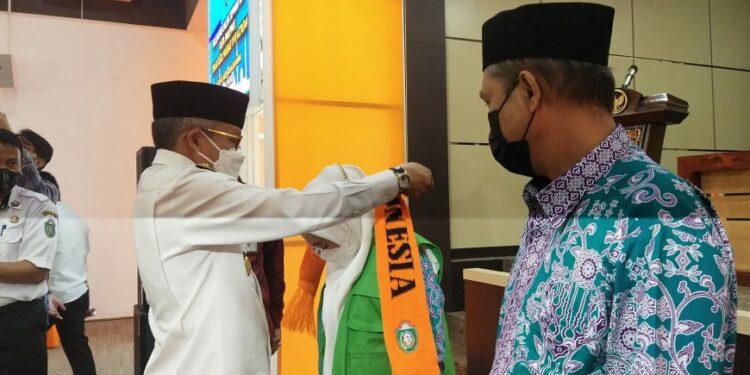 Wali Kota Parepare, HM Taufan Pawe saat memasangkan rompi kepada salah seorang Jemaah Calon Haji (JCH) Kota Parepare di Auditorium BJ Habibie, baru-baru ini. --ist--