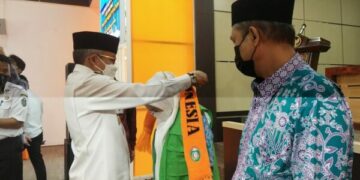 Wali Kota Parepare, HM Taufan Pawe saat memasangkan rompi kepada salah seorang Jemaah Calon Haji (JCH) Kota Parepare di Auditorium BJ Habibie, baru-baru ini. --ist--