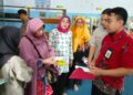 Asesor sekaligsu Pustakawan Dinas Perpustakaan Kota Makassar, Tulus Wulan Juni (kanan) menyambangi salah satu sekolah untuk persiapan akreditasi