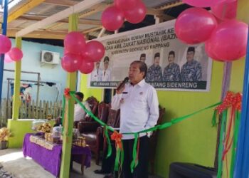 Bupati Sidrap, H. Dollah Mando didampingi Camat Watang Sidenreng, Hidayatullah Abbas, menyerahkan bantuan bedah rumah Badan Amil Zakat Nasional (Baznas) Sidrap pada Kamis (1/9/2022).