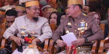 Gubernur Sulsel, Andi Sudirman Sulaiman berbincang akrab dengan Bupati Gowa, Adnan Purichta dalam perayaan 702 tahun Hari Jadi Gowa di Kawasan Museum Balla Lompoa, Kamis (17/11/2022)