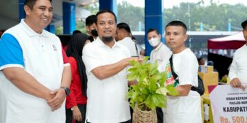 Didampingi Bupati Maros, Chaidir Syam, Gubernur Sulsel Andi Sudirman Sulaiman memberikan bibit kopi kepada seorang warga.