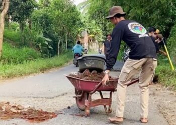 Anggota Ganesa Peduli lakukan penambalan jalan di Dusun Lekong Lima, Desa Montong Betok, Kecamatan Montong Gading, Kabupaten Lombok Timur, Provinsi Nusa Tenggara Barat (NTB).