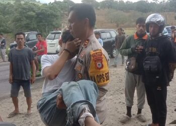 Kapolsek Watangpulu IPTU Ahmad Tangko, menggendong korban pengendara Motor Insiden Tabrakan Beruntun untuk Dievakuasi ke Puskesmas.