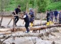 Pj Gubernur Sulsel, Bahtiar Baharuddin harus meniti jembatan bambu di atas sungai dengan arus deras untuk tiba di lokasi bencana, Kamis, (9/5/2024). (Foto: Humas Pemprov Sulsel)
